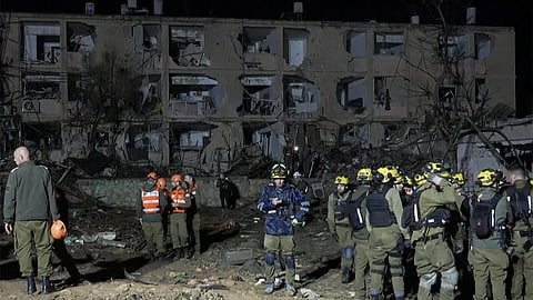 This frame grab from AFPTV footage shows first responders inspecting the site of an Iranian missile strike in Dimona on March 21, 2026.
