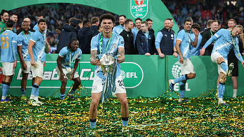 Manchester City's Nico O'Reilly celebrates with the trophy after winning the English League Cup final soccer match between Arsenal and Manchester City in London, Sunday, March 22, 2026. 