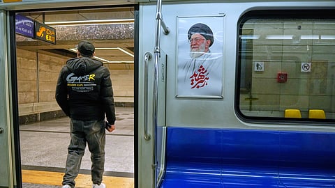 A man leaves a subway train past an image of the late Iranian Supreme Leader Ayatollah Ali Khamenei in Tehran, Iran, Friday, March 13, 2026.