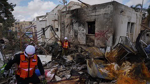 Israeli security forces survey the site that was struck by an Iranian missile in Dimona, southern Israel, Sunday, March 22, 2026. 