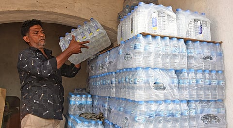 A shopkeeper arranges mineral water bottles kept for sale at Gandhi market in Tiruchy on Thursday.
