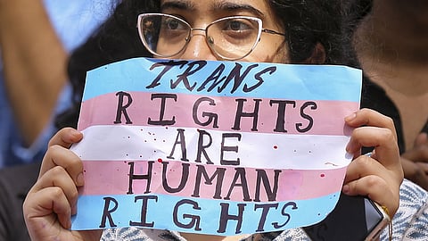 A supporter of the LGBTQIA+ community holds a placard during a protest against the passage of the Transgender Persons (Protection of Rights) Amendment Bill, 2026
