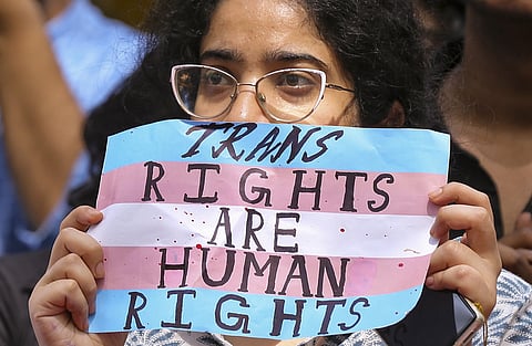 A supporter of the LGBTQIA+ community holds a placard during a protest against the passage of the Transgender Persons (Protection of Rights) Amendment Bill, 2026