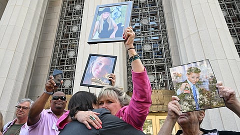 Lori Schott, center, is embraced as she holds up a photo of her daughter Annalee Schott, after the verdict in a landmark trial over whether social media platforms deliberately addict and harm children at Los Angeles Superior Court, Wednesday, March 25, 2026, in Los Angeles. 