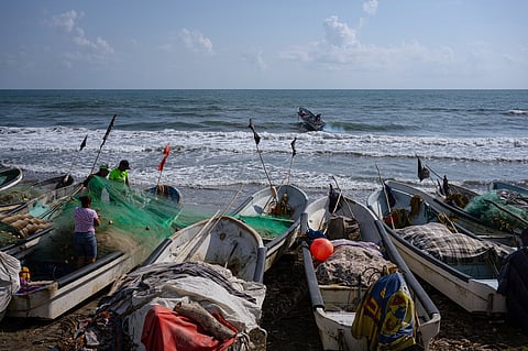 Fishermen untangle a net after suspending fishing trips because of an oil spill in the Gulf of Mexico that authorities said originated from an unidentified vessel and two natural oil seeps in Salinas, Mexico, Thursday, March 26, 2026.