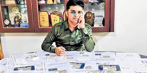 Arvind Kumar Pai with his one-rupee notes bearing serial numbers matching the birth dates of members of the assembly