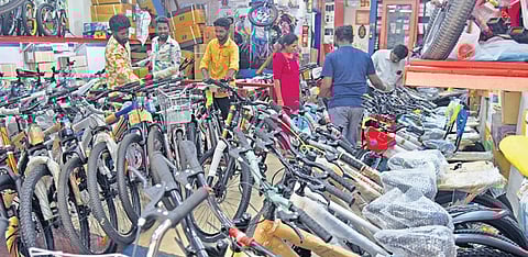 People examine different models of bicycles at a shop in Bengaluru on Thursday