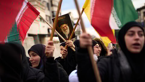 A woman holds a portrait of Iran's late Supreme Leader Ayatollah Ali Khamenei during a protest outside Iran's embassy, where dozens of people gathered waving Hezbollah and Iranian flags in solidarity with the Islamic Republic, in Beirut, Lebanon, Thursday, March 26, 2026.