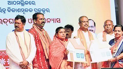 Union Minister Pradhan with housing scheme beneficiaries at Athmallik on Tuesday