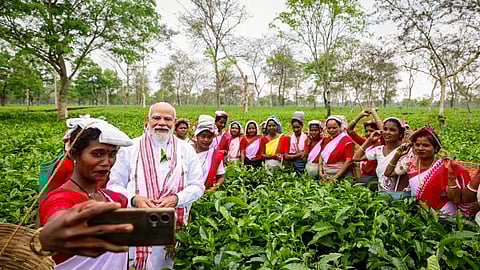Prime Minister Narendra Modi poses for photographs with women workers at a tea garden, in Dibrugarh, Assam.