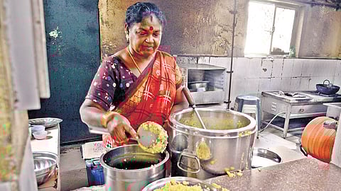 A staff member serving food at Amma canteen in Porur.