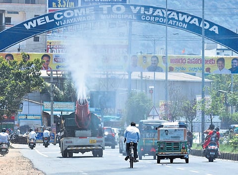 A mist vehicle sprays water on the streets in Vijayawada to reduce pollution and improve air quality.