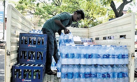 A water supplier unloading bottled water and cool drinks for retail stores.