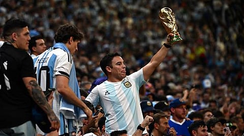 An Argentina supporter holds a replica of the FIFA World Cup Trophy after Argentina won the Qatar 2022 World Cup final football match between Argentina and France at Lusail Stadium in Doha