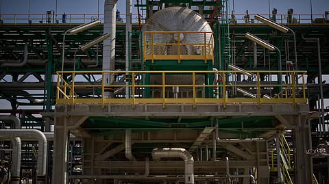 Men work on the maintenance of a pipe at a degassing station in the Zubair oil field, whose operations have been reduced due to the Mideast war triggered by the US and Israeli attacks on Iran, near Basra, Iraq, Saturday, March 28, 2026.