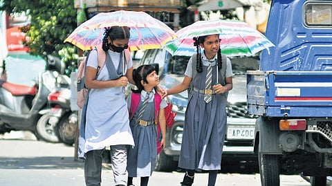 School children use umbrellas to protect themselves from scorching heat as they return to their homes on a sunny afternoon in Vijayawada on Thursday. 