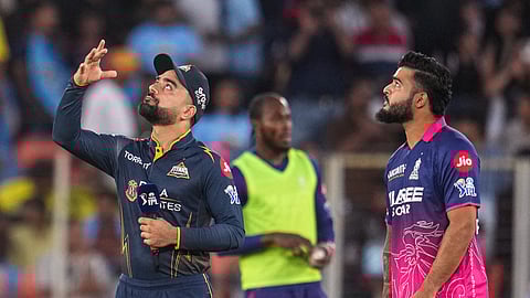 Gujarat Titans' captain Rashid Khan, left, flips the coin as Rajasthan Royals' captain Riyan Parag takes the call during the toss before an Indian Premier League (IPL) 2026 T20 cricket match between Gujarat Titans and Rajasthan Royals, in Ahmedabad, Gujarat, Saturday, April 4, 2026. 
