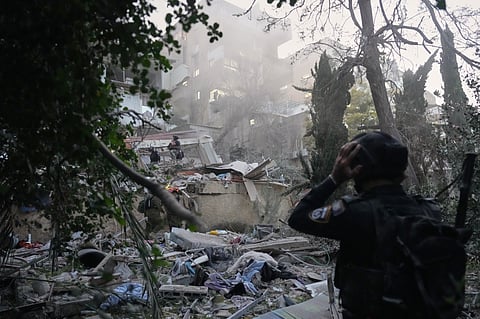 Israeli security forces and rescue teams work amid the rubble of a residential building struck by an Iranian missile in Haifa, Israel, Sunday, April 5, 2026.