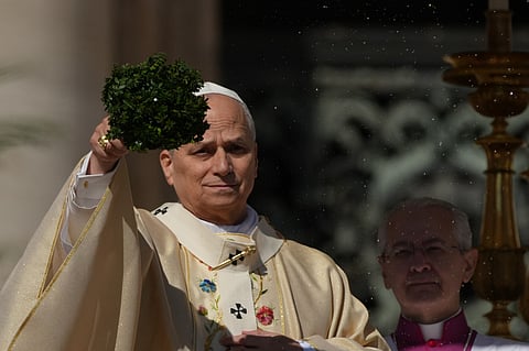 Pope Leo XIV sprinkles holy water with a bunch of hyssop sprigs as he presides over Easter Mass in St. Peter’s Square at the Vatican, Sunday, April 5, 2026.