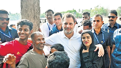 Rahul Gandhi posing with residents, who were waiting for him near the helipad arranged at Mercy College Ground, on Monday.