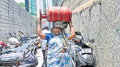 A woman carries a 15kg cylinder to her home in Bengaluru 
on Monday 