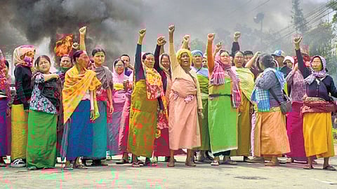 People block a road after two kids were killed in Bishnupur district of Manipur.