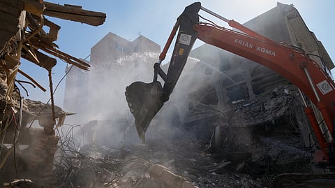 An excavator removes rubble at the site of a strike that, according to a security official at the scene, destroyed half of the Khorasaniha Synagogue and nearby residential buildings in Tehran, Iran, Tuesday, April 7, 2026.