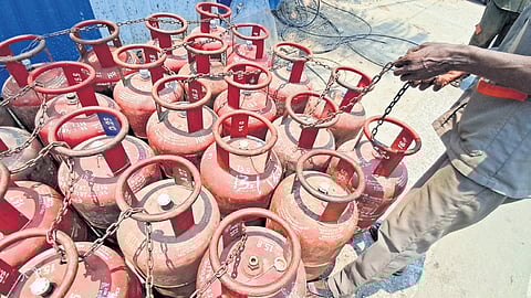 A LPG delivery person putting a lock to the empty cyclinders kept on the roadside at patravakkam in Chennai.