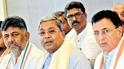 Chief Minister Siddaramaiah, flanked by Deputy Chief Minister DK Shivakumar and AICC general secretary Randeep Singh Surjewala.
