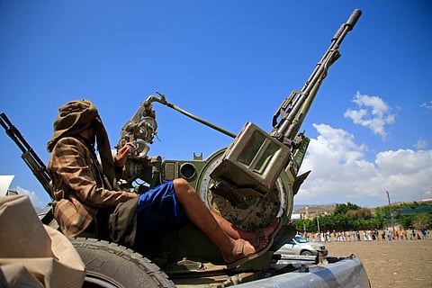 A supporter of the Iran-backed Houthi movement, brandishes his weapon as he rallies in solidarity with Iran and Lebanon, in Sanaa on April 8, 2026, following the announcement of a ceasefire in the Middle East war.