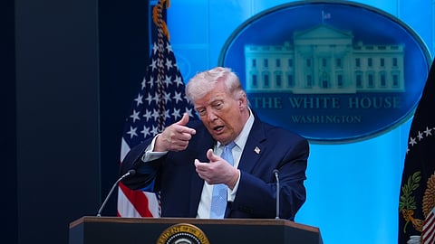 US President Donald Trump pretends to aim a sniper gun while speaking with reporters in the James Brady Press Briefing Room at the White House, Monday, April 6, 2026, in Washington.