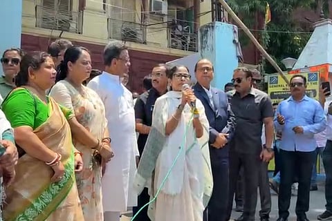 Wearing her trademark simple attire and greeting people with folded hands and a smile, Banerjee acknowledged party workers lined along both sides of the road as she walked