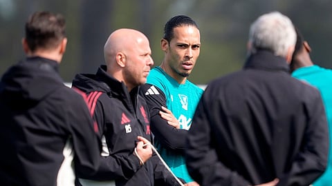 Liverpool's Virgil van Dijk, center, and manager Arne Slot, second left, attend a training session in Liverpool, England, Tuesday April 7, 2026.