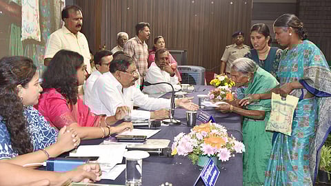 Home Minister Dr G Parameshwara listens to the grievances of an elderly woman in Tumakuru on Wednesday.