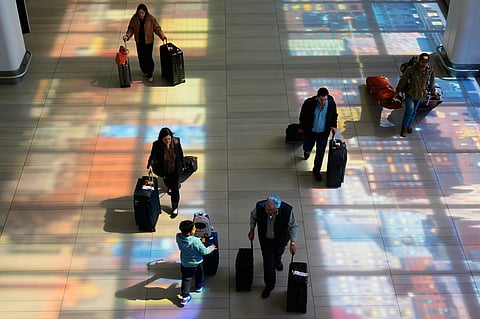Stained-glass windows cast colorful shadows on the floor as travelers walk through LaGuardia Airport in New York, Monday, March 30, 2026.