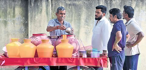 People line up to buy buttermilk and ragi ambli to cool their body amid rising temperatures on Ulsoor Road on Sunday 
