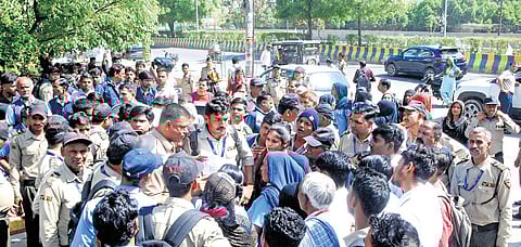 Security guards stage a protest over fee hike issues outside a residential society at Sector 74, in Noida, Tuesday, April 14, 2026.