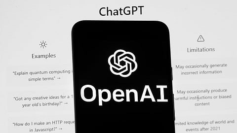 The OpenAI logo is seen on a mobile phone in front of a computer screen which displays the ChatGPT home Screen, March 17, 2023, in Boston.