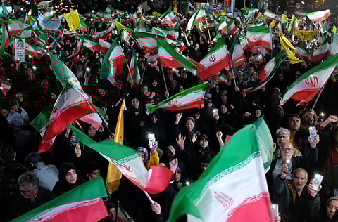Pro-government demonstrators wave Iranian national flags at a gathering in Tehran, Iran, Saturday, April 11, 2026.