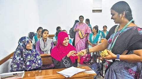 A lecturer distributes chocolates to students as they passed with good marks in Intermediate Public Examinations in Vijayawada on Wednesday.