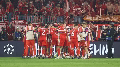 FC Bayern Munich players celebrate with the fans after winning the UEFA Champions League quarter-final second leg football match between FC Bayern Munich and Real Madrid in Munich, southern Germany, on April 15, 2026.