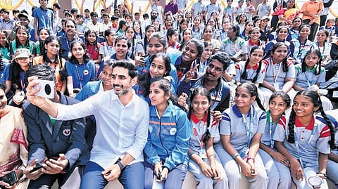 HRD and IT Minister Nara Lokesh takes a selfie with students after inaugurating sports infrastructure projects worth Rs 35 crore 
in Tirupati on Wednesday.