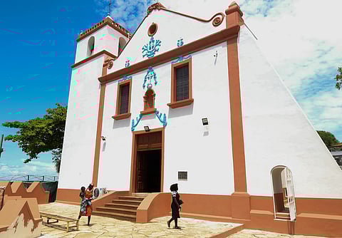 People walk by the Church of Our Lady of Muxima in Muxima, Angola, Saturday, April 11, 2026, which Pope Leo XIV will visit during his 11-day pastoral visit to Africa.