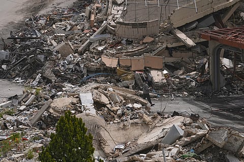 A man walks between destroyed buildings on the second day of a ceasefire between Hezbollah and Israel in Nabatiyeh town, south Lebanon, Saturday, April 18, 2026.