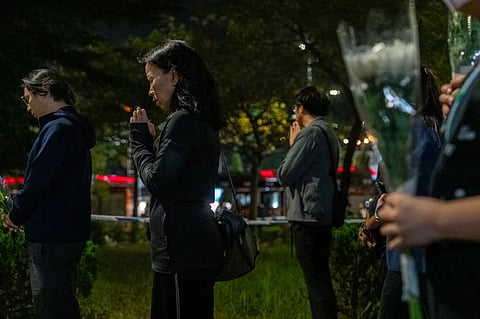 People offer flowers and pray for the victims near the site of Wednesday’s fire at Wang Fuk Court, a residential estate in the Tai Po district of Hong Kong’s New Territories, Sunday, Nov. 30, 2025. 