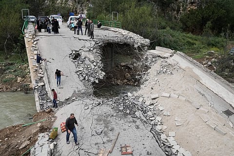 Displaced people cross a destroyed bridge they return to their villages, following a ceasefire between Hezbollah and Israel, in Tayr Felsay village, southern Lebanon, Sunday, April 19, 2026. 