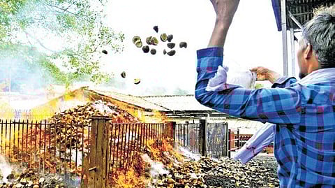 Pilgrims throwing broken coconuts into the ‘aazhi’ after ‘neyyabhishekam’ at Sabarimala temple.