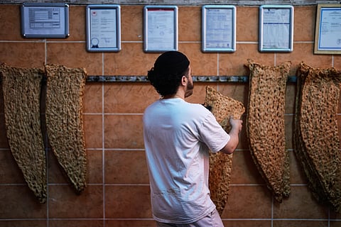 A baker hangs bread in an Iranian bakery in Istanbul on Tuesday, April 14, 2026. 