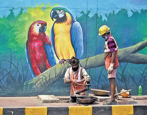 VMC sanitation workers removing accumulated silt from a drain at Raghavaiah Park on MG Road in Vijayawada 