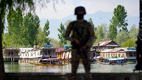 A security official keeps vigil along the Dal Lake area amid heightened security ahead of the Pahalgam attack anniversary, in Srinagar, Tuesday, April 21, 2026.